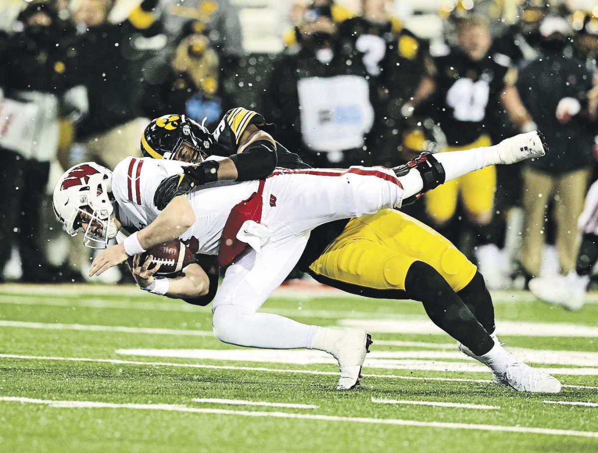 Iowa Hawkeyes defensive lineman Chauncey Golston (57) sacks Wisconsin Badgers quarterback Graham Mertz (5) during the third quarter of their game at Kinnick Stadium in Iowa City, Iowa on Saturday, December 12, 2020. The Hawkeyes play the Badgers on Oct. 30 this season. (Stephen Mally/hawkeyesports.com)