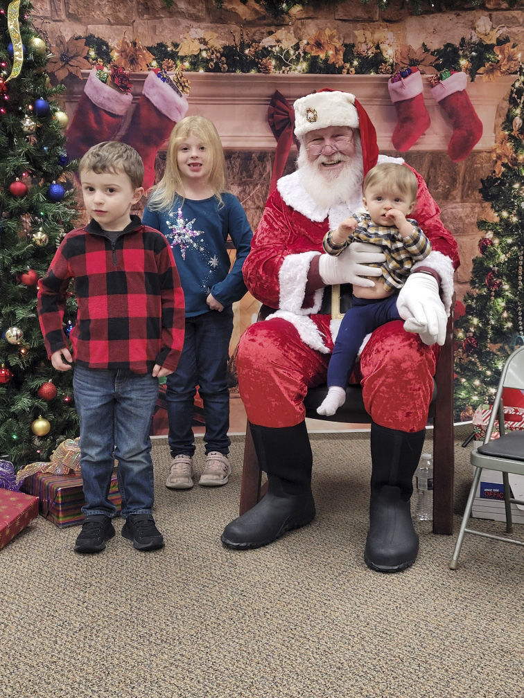From left, Grant, Madelyn and Amelia Moses visit with Santa during his visit to Solon State Bank, Dec. 10.