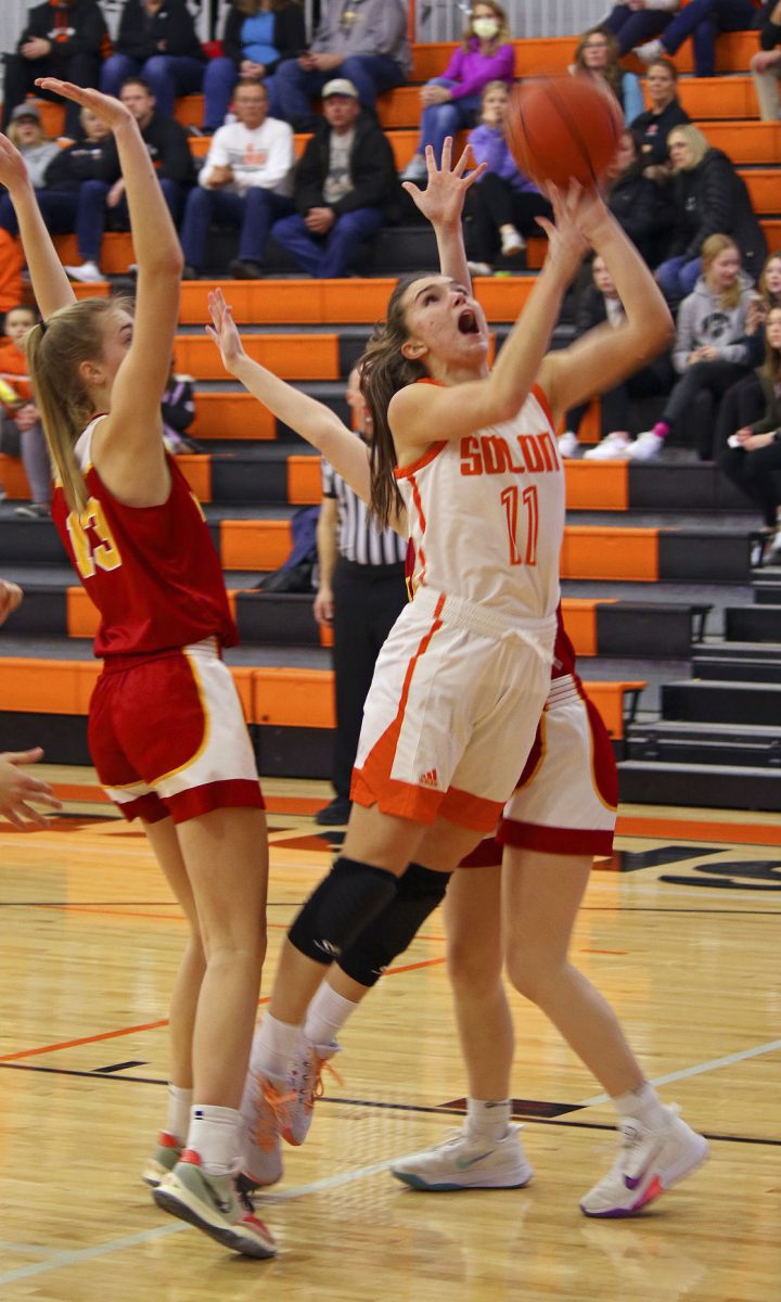 <p>Solon senior Kaia Holtkamp splits two Marion Wolves on her way to the basket, at home, during the Lady Spartans’ 53-42 triumph over WaMaC rival Marion, Jan. 18.</p>