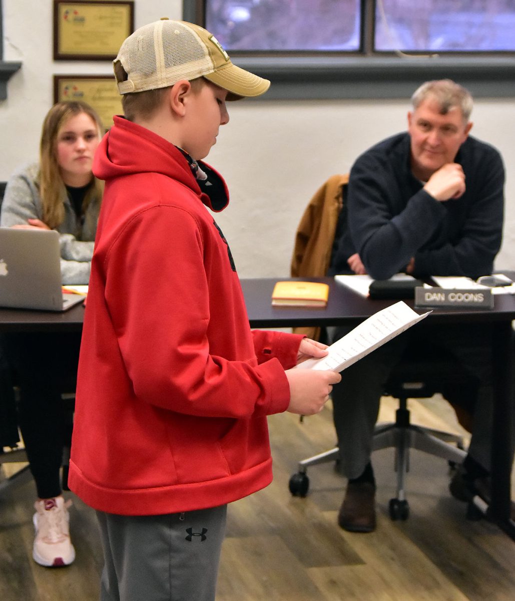 Henry Horsfield, a fifth grader, reads his persuasive argument essay on the value of pets in the classrooms to the Solon Community School District&#8217;s Board of Education Thursday, Feb. 17. Looking on are student member Hillary Wilson, and board member Dan Coons.