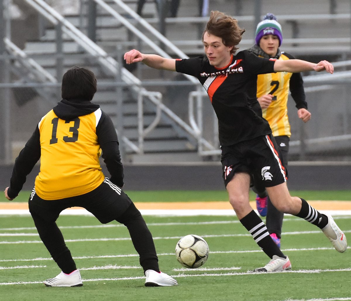 Sophomore Eli Freerks passes the ball to a teammate Thursday, March 24, in a scrimmage match against Mid-Prairie. Freerks scored the fourth goal in the 4-1 victory.