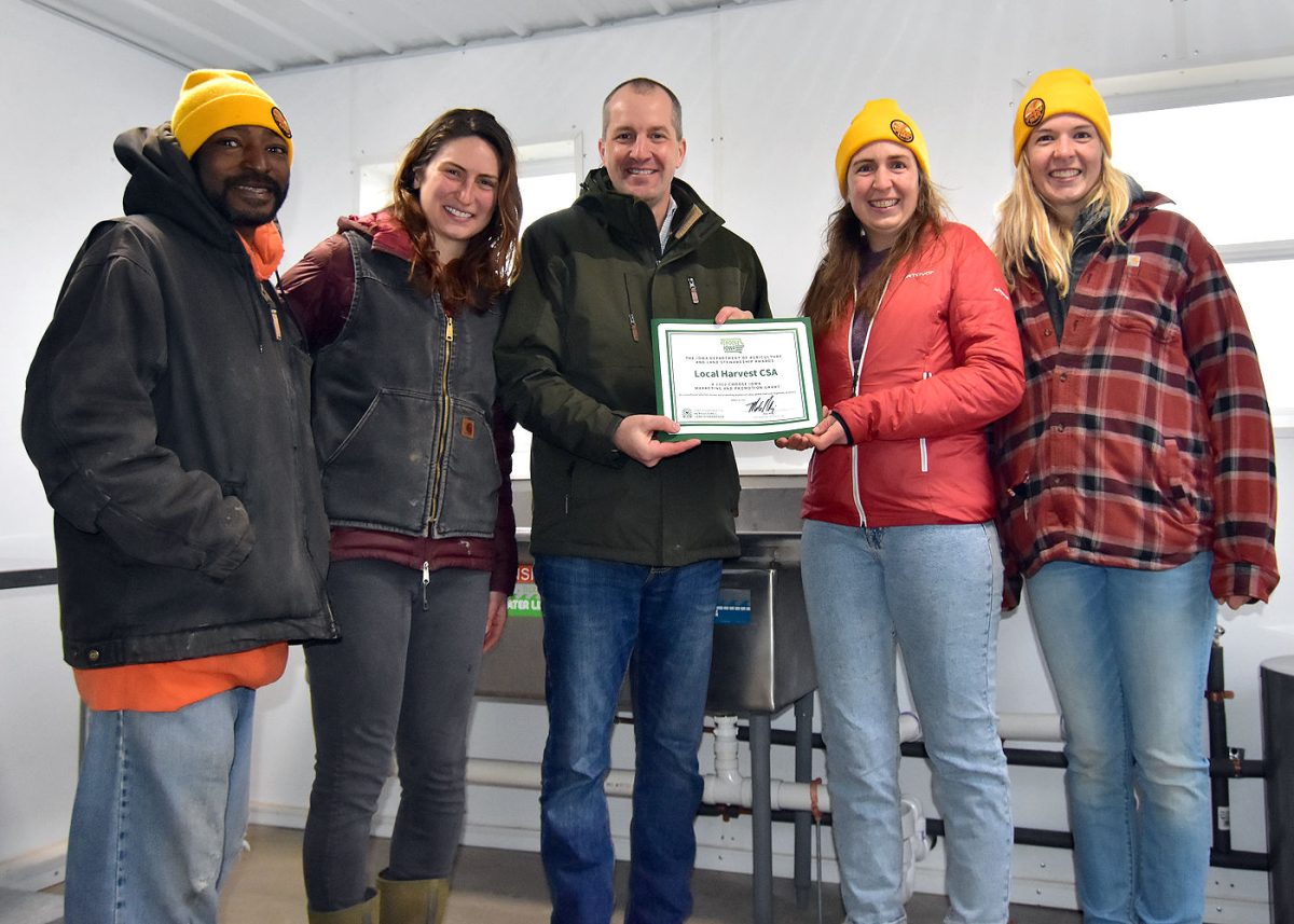 <p>Iowa Secretary of Agriculture Mike Naig presents a $5,750 Choose Iowa grant to Carlos Williams, Helaina Thompson, Carmen Black and Maja Black, representing the Local Harvest CSA located near Solon. Naig visited the Sundog Farm CSA Friday, March 25.</p>