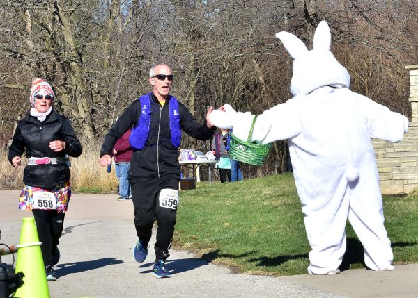 Tiffany Miller and Ted Smith, from Cedar Rapids, receive a congratulatory high-five near the finish line of a 10-mile run Saturday, April 9, at the Solon Nature and Recreation Area. We Run sponsored the event including a 25k and 50k run.