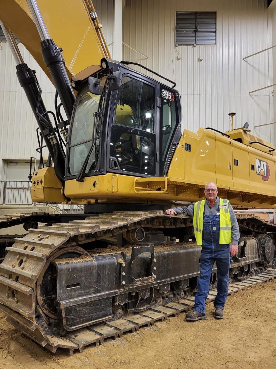 Jay Proffitt, owner of Proffitt Construction, Inc. poses with a large Caterpillar excavator at a trade show in Peoria, IL. Proffitt is truly a &#8220;go-to guy&#8221; for Solon through countless acts of service to the community.