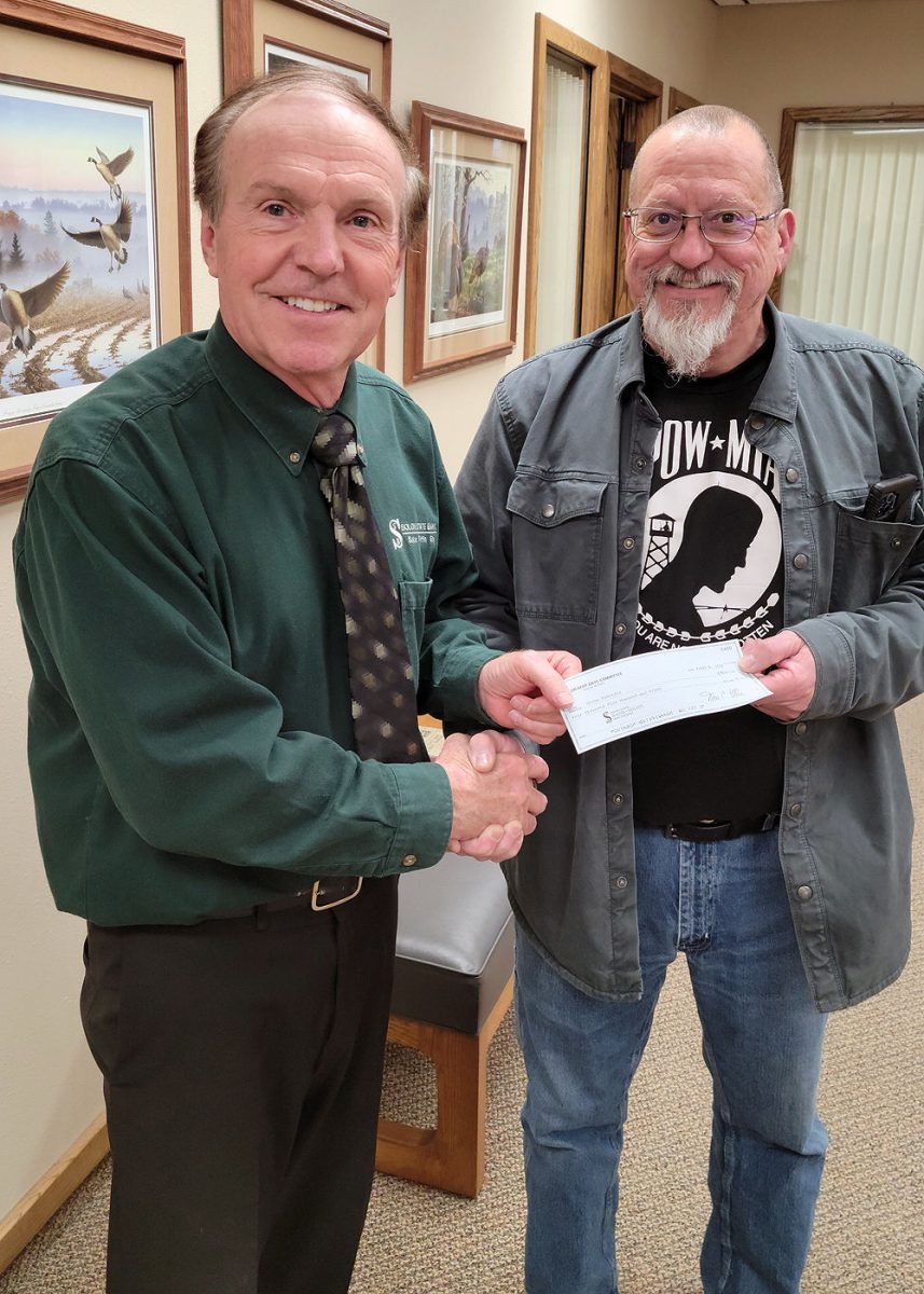 Don C. Ellis, treasurer of the Solon Beef Days Committee, presents a $4,500 check to Coach Bill Mattaliano of Solon Robotics to be used for new laptops, tablets, a competition field perimeter and tiles and consumable parts for building robots in the 2022-2023 season.