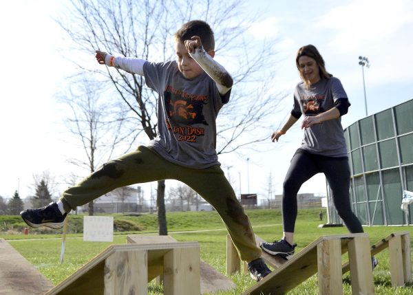 Participants in the 2022 Spartan Dash negotiate the “Spartan Ninja Warrior” obstacle.