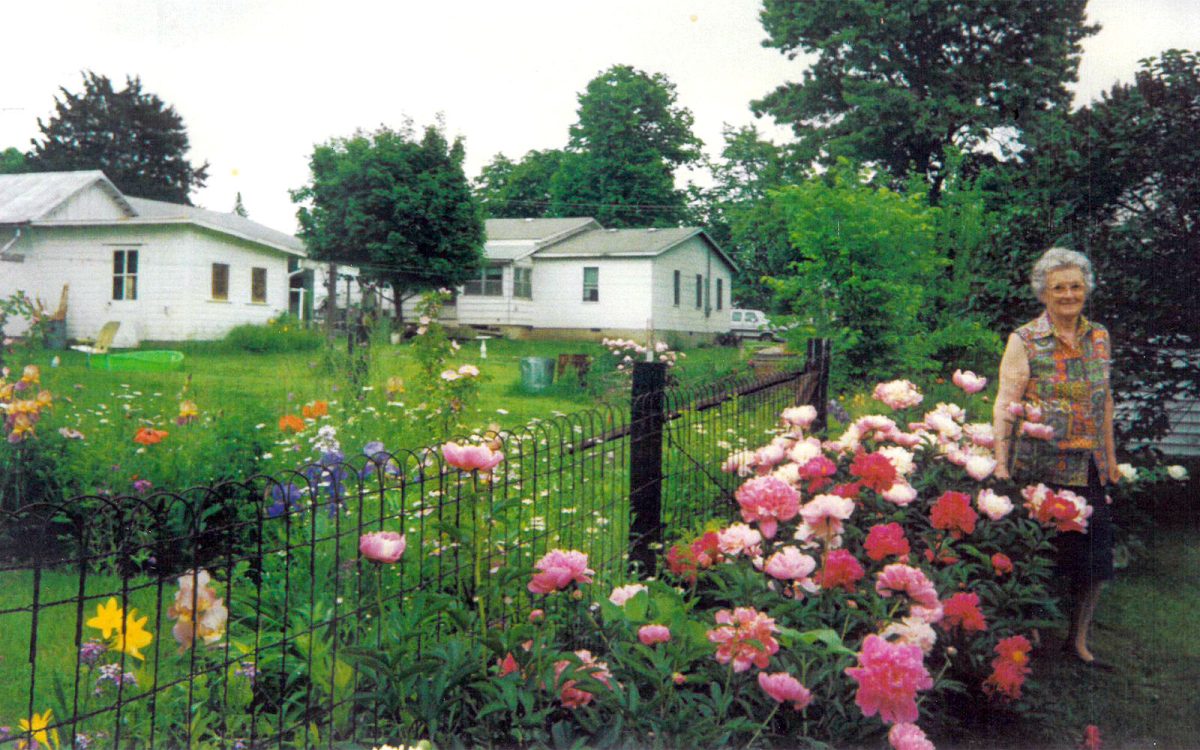 Mary Sovers stands by her peonies.