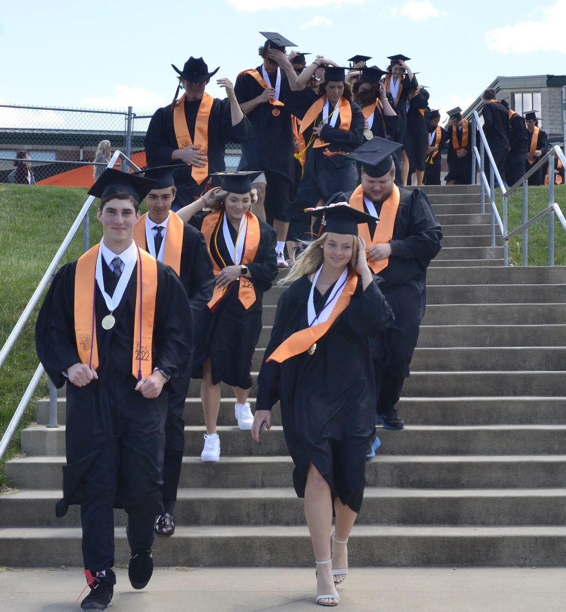 The Class of 2022 tries to keep their caps from blowing away as they walk down the steps to the field in Spartan Stadium Sunday, May 22 for their graduation ceremony.