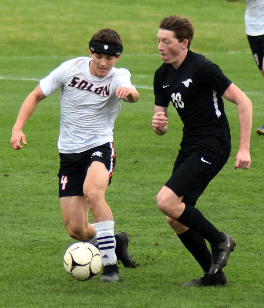 Logan Sieverding races Mount Vernon&#8217;s Ben Nydegger up field Friday, April 29, at Cornell College, in Mount Vernon. The Spartans defeated their rivals, 2-1, in sudden death overtime.