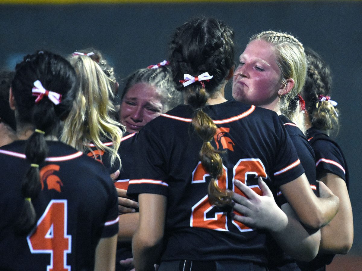 <p>Varsity softball players hug and console each other after a 7-6 loss (in extra innings) to Marion in the first round of regional competition Thursday, July 7.</p>