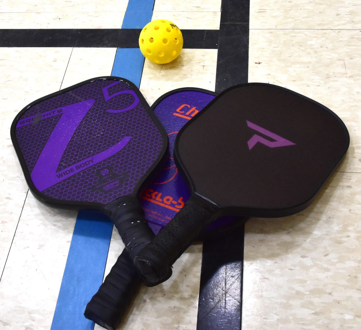 <p>Pickleball paddles and a ball sit at the junction of basketball and pickleball courts in the Solon United Methodist Church’s Family Life Center. New permanent floor markings were recently installed providing for three pickleball courts plus a volleyball and basketball court.</p>