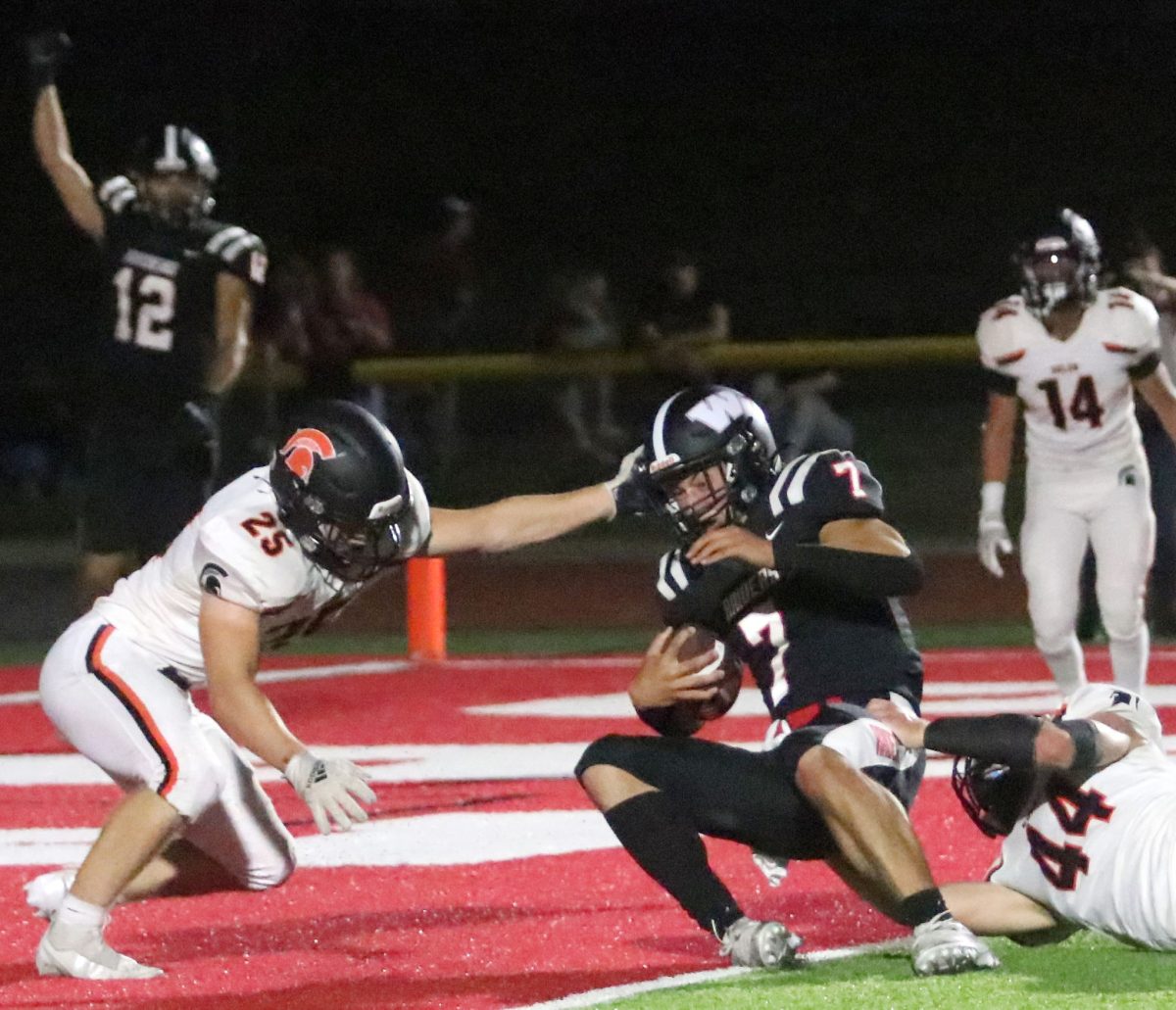 <p>Brayden Moore (25) and Austin Bell (44) try to keep a Williamsburg Raider out of the end zone Friday, Sept. 9 in Williamsburg. The Raiders handed the Spartans their second loss of the season.</p>