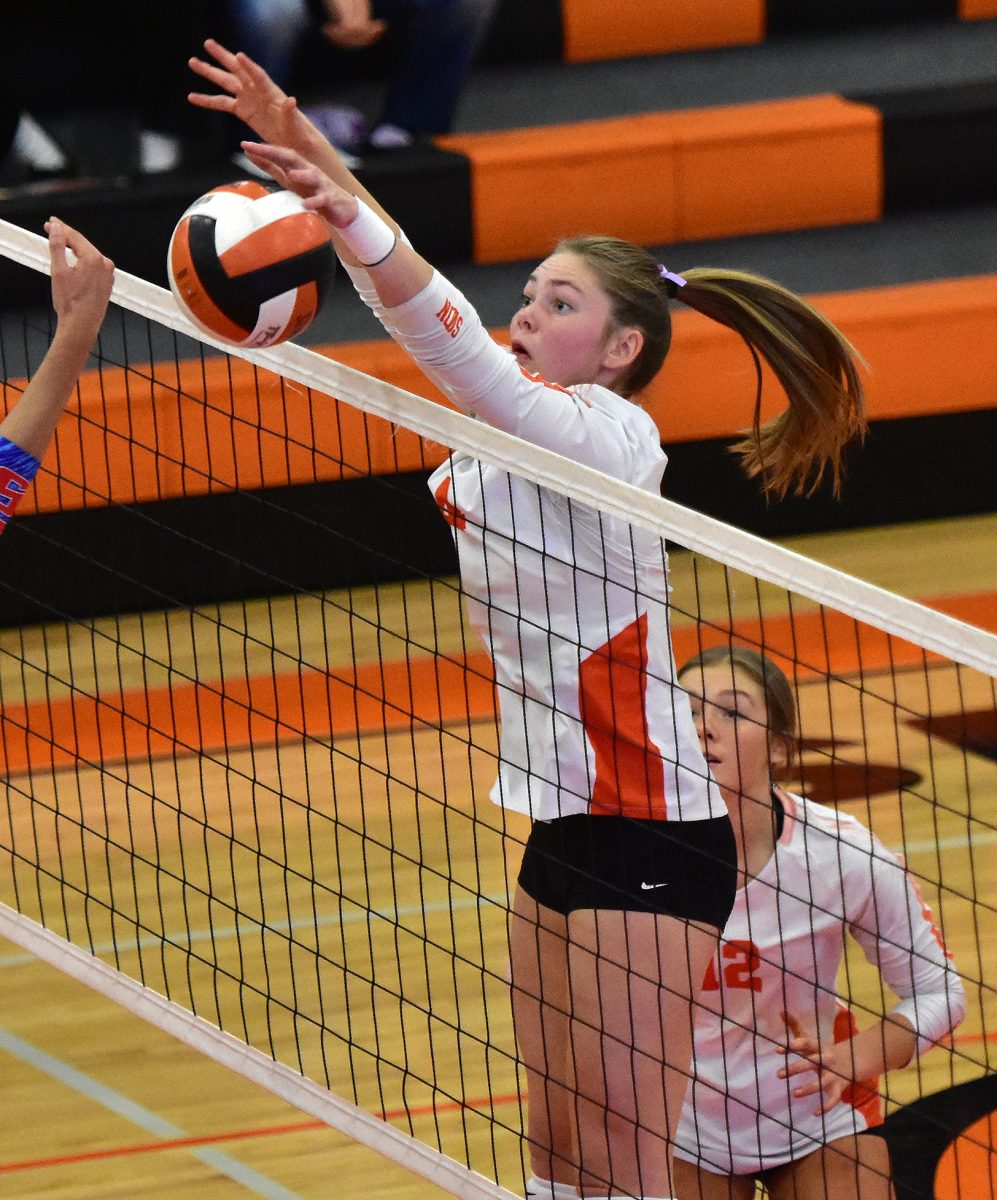 Brynn Deike (12) watches as Grace Erwin (4) smacks the ball down over the net for one of her six kills against the Albia Blue Demons Wednesday, October 19 at home in a 3A Region 7 semifinal match.