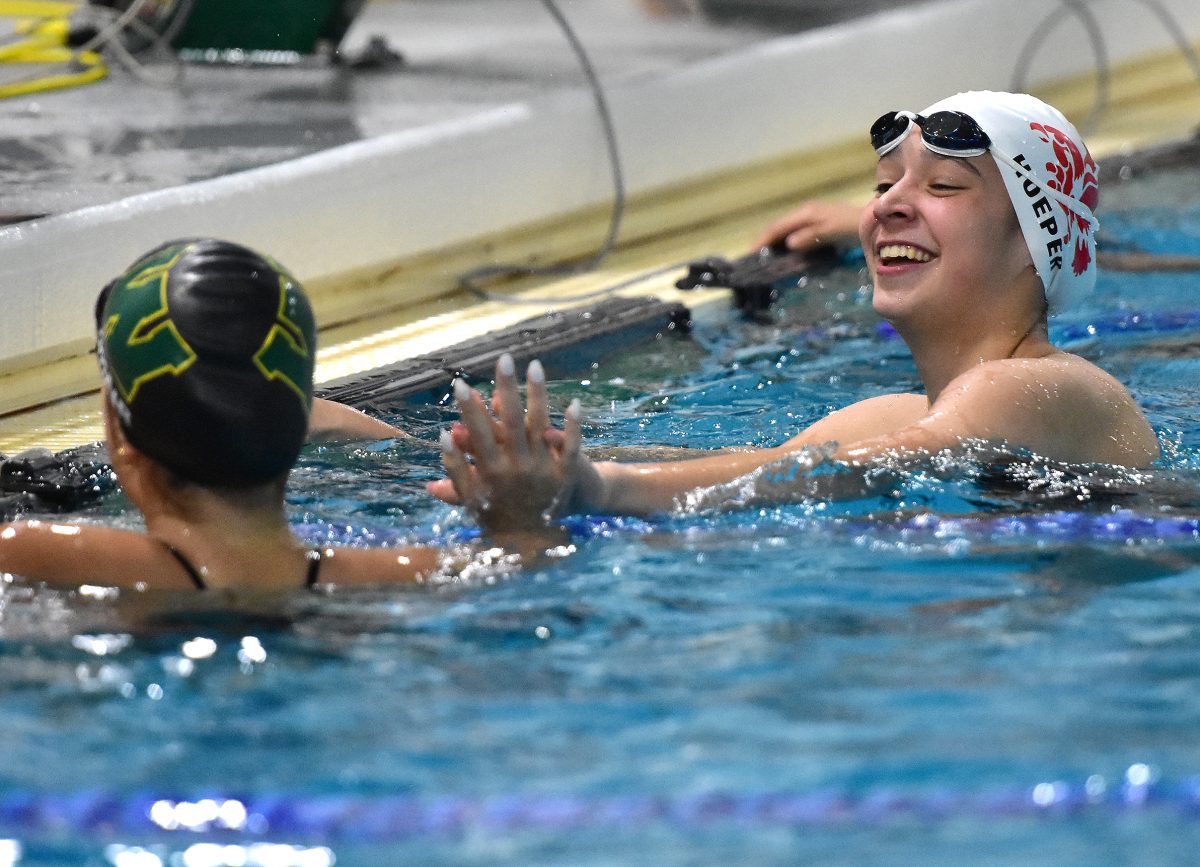 Grace Hoeper congratulates a West High/Liberty High swimmer at the end of the varsity 200-yard freestyle Tuesday, Sept. 27 in Coralville during the annual City High-West High rivalry meet. The Solon sophomore recently earned MVC All-Division honors.