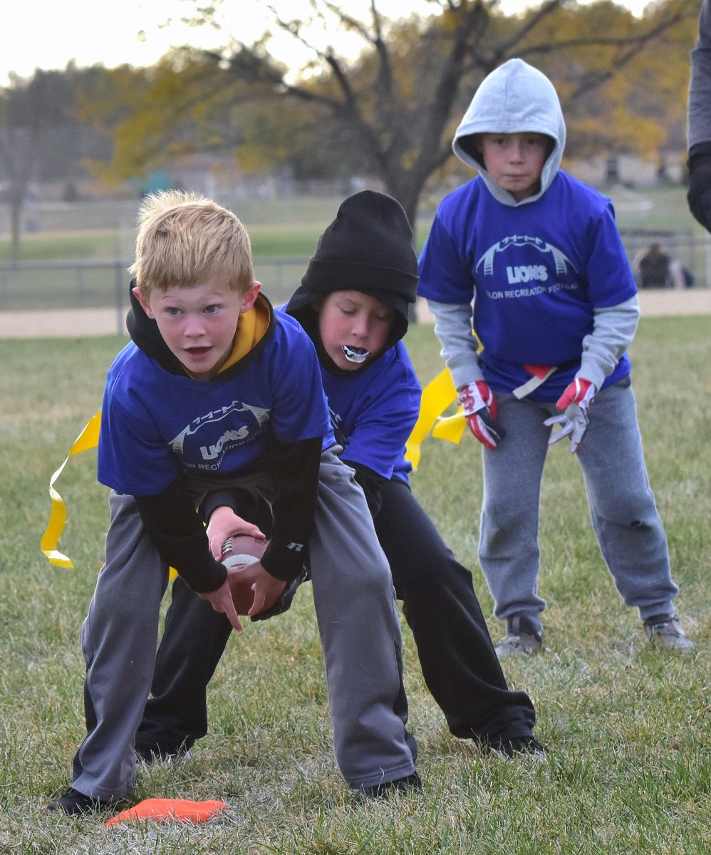 A young quarterback takes the snap on the final night of the Solon Parks &amp; Recreation Dept. flag football season Monday, October 17 at the SRNA.