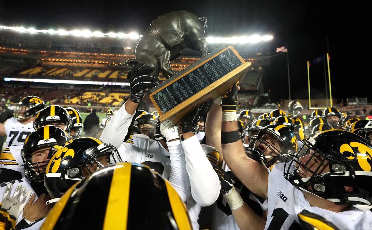 <p>The Iowa Hawkeyes celebrate with the Floyd of Rosedale trophy following their win against the Minnesota Golden Gophers Saturday, Nov. 19 at Huntington Bank Stadium.</p>