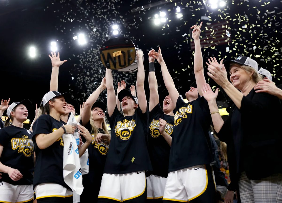 Caitlin Clark hoists the trophy as the Iowa Hawkeyes celebrate their win against the Ohio State Buckeyes in the championship game of the 2023 Big Ten Women&#8217;s Basketball Tournament Sunday, March 5 at the Target Center in Minneapolis.