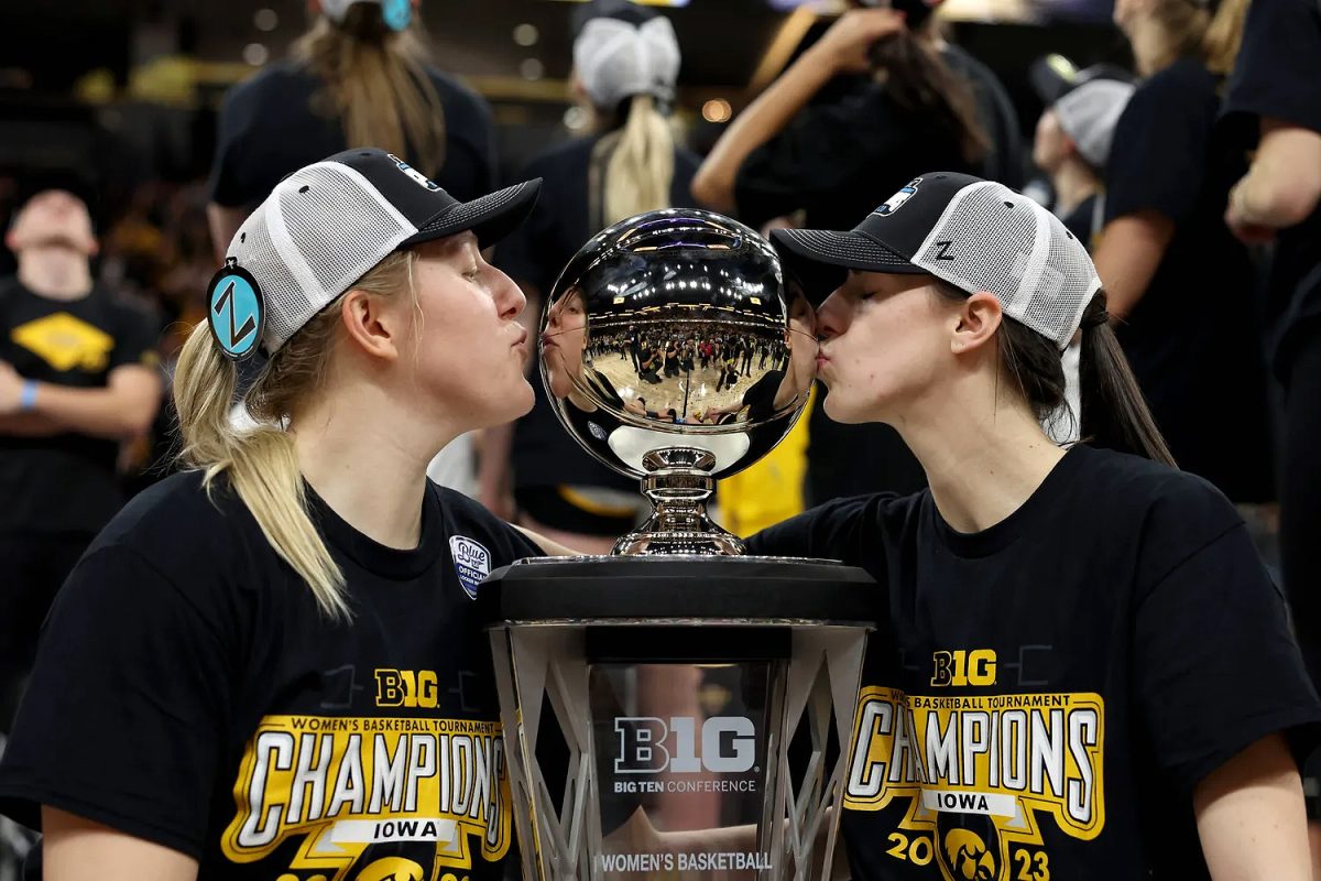 Monika Czinano and Caitlin Clark kiss the trophy following their win against the Ohio State Buckeyes in the championship game of the 2023 Big Ten Women&#8217;s Basketball Tournament Sunday, March 5 at the Target Center in Minneapolis.