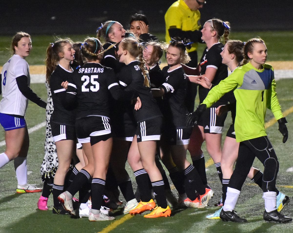 The Lady Spartans celebrate a 2-1 sudden death win in overtime over the Clear Creek Amana Clippers Thursday, April 6 at home as CCA&#8217;s Alannah McKibben (1) and Kenadi Wood (8) return to their bench.