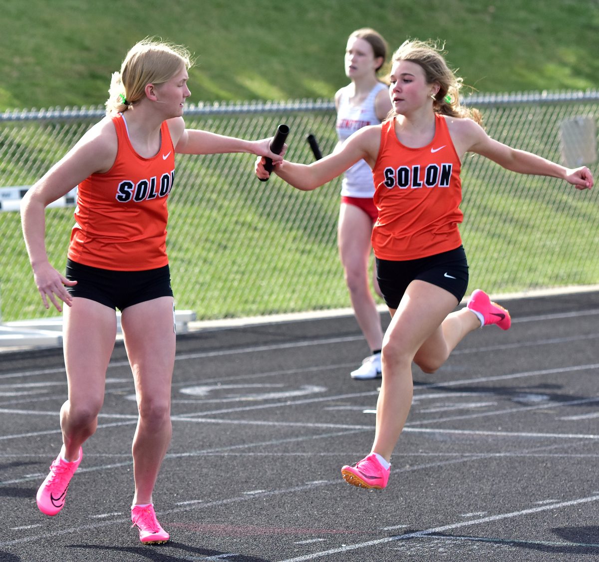 <p>Piper Stahle hands off to Kobi Lietz for the anchor leg of the sprint medley relay during the annual Denny Gruber Co-Ed Relays Tuesday, April 18. Emma Wolf, Hailey Miller, Piper Stahle, and Kobi Lietz crossed second in 1:55.22 and will compete this weekend in the Drake Relays as the No.1 seed.</p>