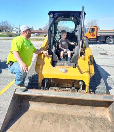 Kris Richardson, Solon Public Works, shows a friend how the controls work in the track loader.