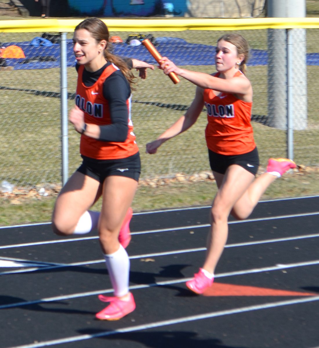 <p>Piper Stahle leans into the baton exchange to Sophia Stahle in the Tipton meet.</p>