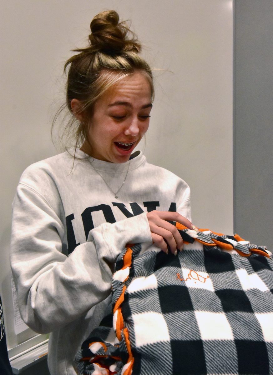 <p>Elizabeth “Biz” Petrie reacts when she sees her name embroidered on a blanket made and donated by Solon Intermediate School (SIS) 4th graders. The students also raised $400 for her through blanket sales to help with her ongoing medical expenses.</p>