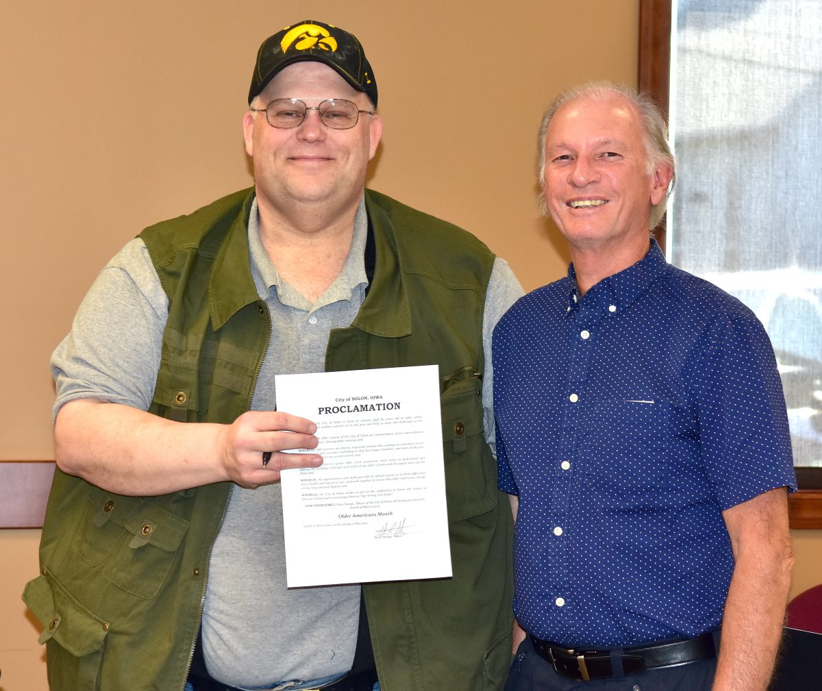 Mayor Steve Stange (at left) and William Gorman (representing the Johnson County Livable Community for Successful Aging Policy Board) pose with the official proclamation declaring May to be Older Americans Month in Solon.