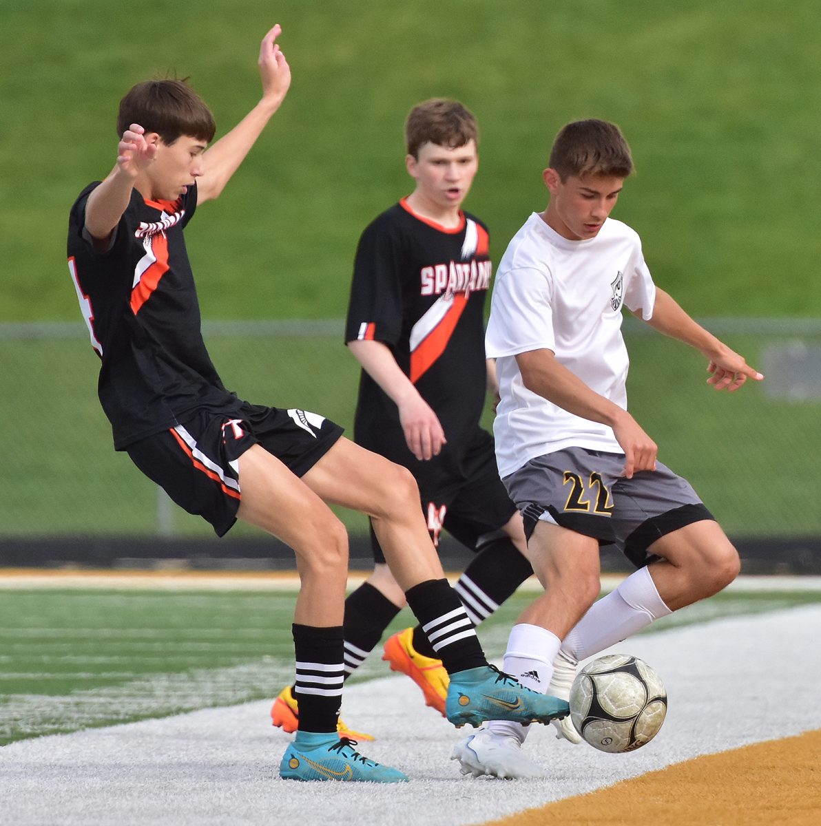 <p>Nate Shafer (14) knocks the ball away from CPU’s Jared Bosenberg (22) as Jack Hosking (40) looks on Tuesday, May 9 at home.</p>