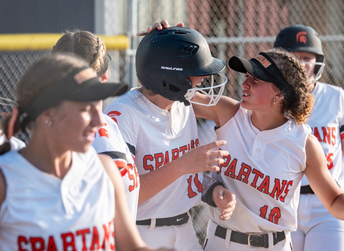 Mia Stahle (10) congratulates Addie Miller (11) on her homerun Monday, June 19 at Benton Community.