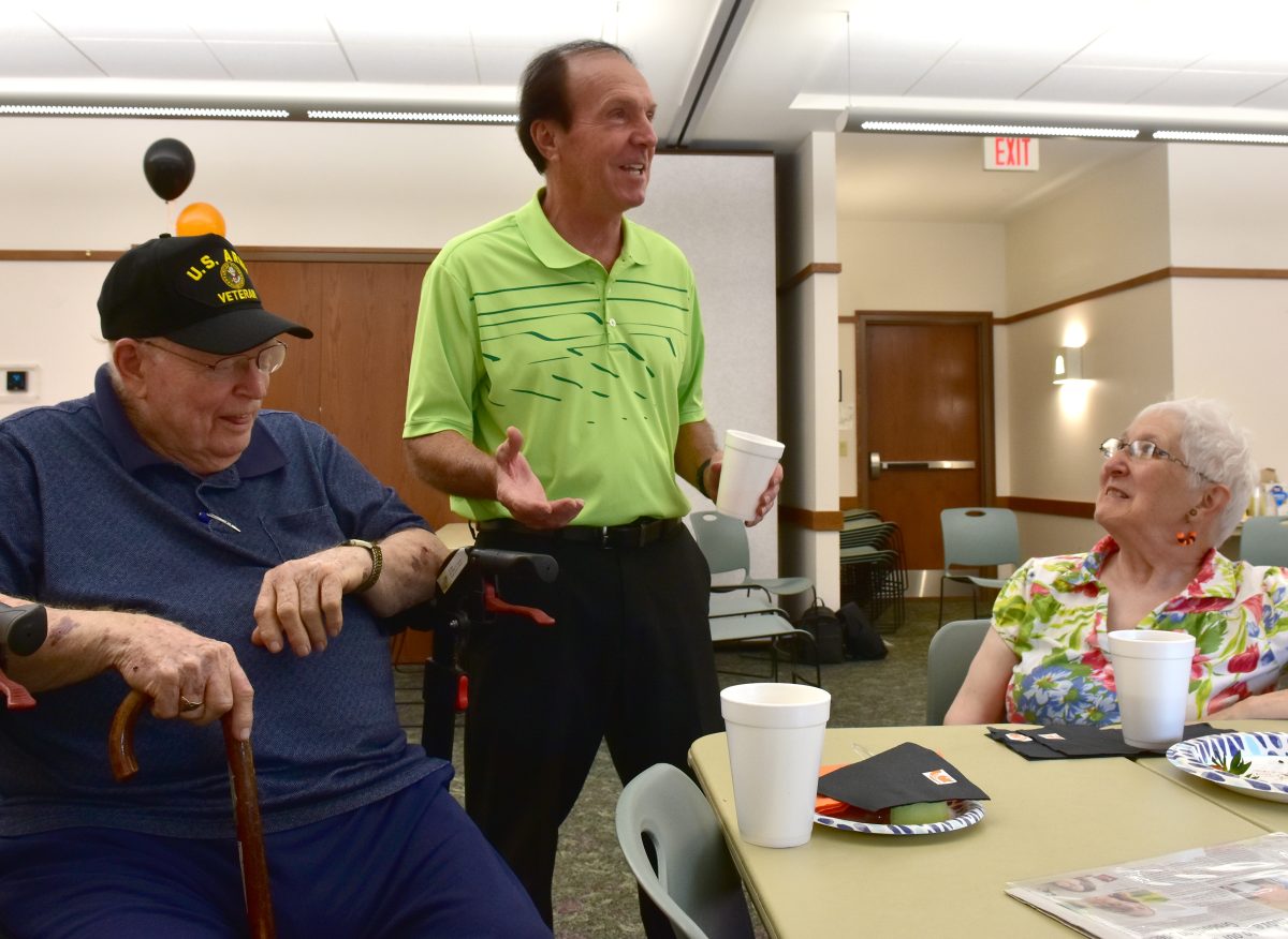 Don Ellis (standing) visits with Art Tellin and Pat Ikan during an open house Saturday, June 24 at the Solon Public Library in honor of Ellis being named the 2023 Solon Senior Citizen of the Year.