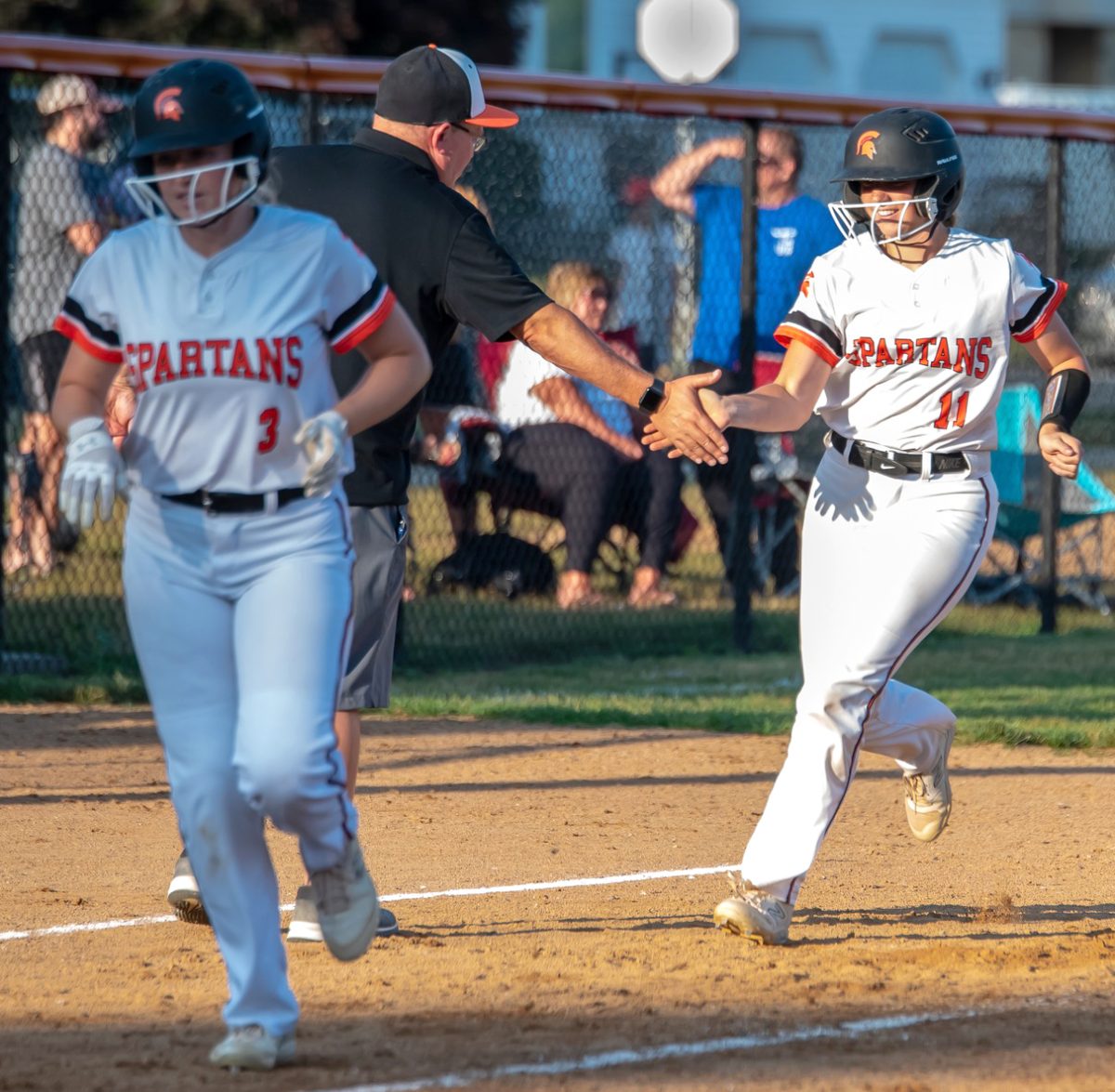 Addie Miller (11) follows Claire LaDage (3) home after smacking the second of two homeruns Monday, June 26 at West Delaware. Miller had three hits total with six RBIs but the Hawks still surprised the Lady Spartans with a pair of losses.