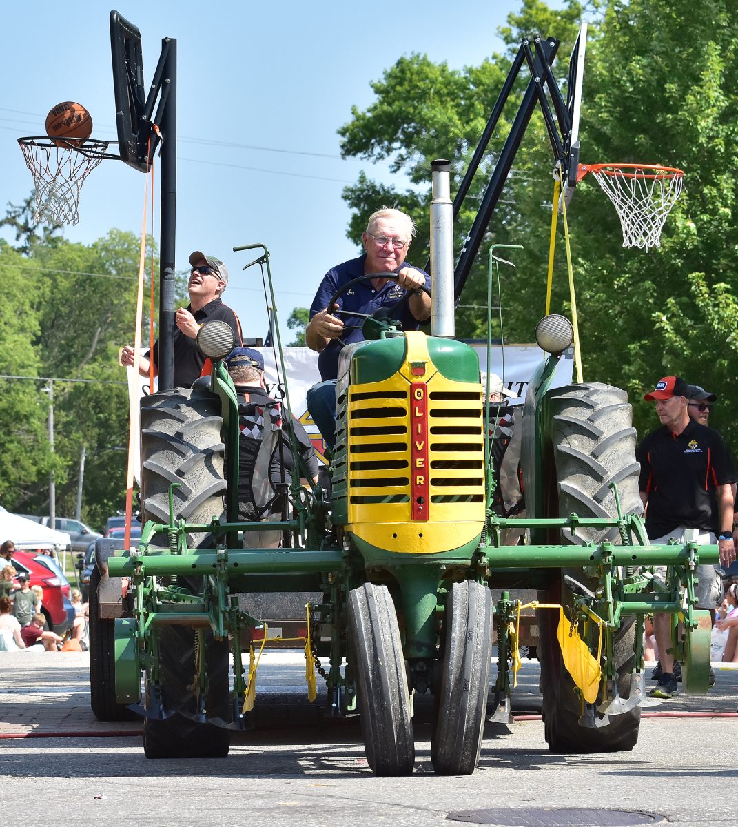 Jim Steinbrech pilots a vintage Oliver tractor pulling the Knights of Columbus&#8217; rolling basketball shooting contest through downtown Solon during the 50th annual Beef Days Parade Saturday, July 22.