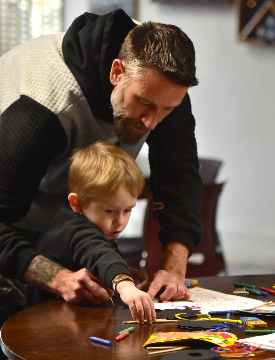 Bowen Brown reaches for another crayon while dad David helps him color a Santa Claus drawing Saturday, Dec. 9 at the Solon American Legion Stinocher Post 460 ahead of a visit from Mr. Claus himself.