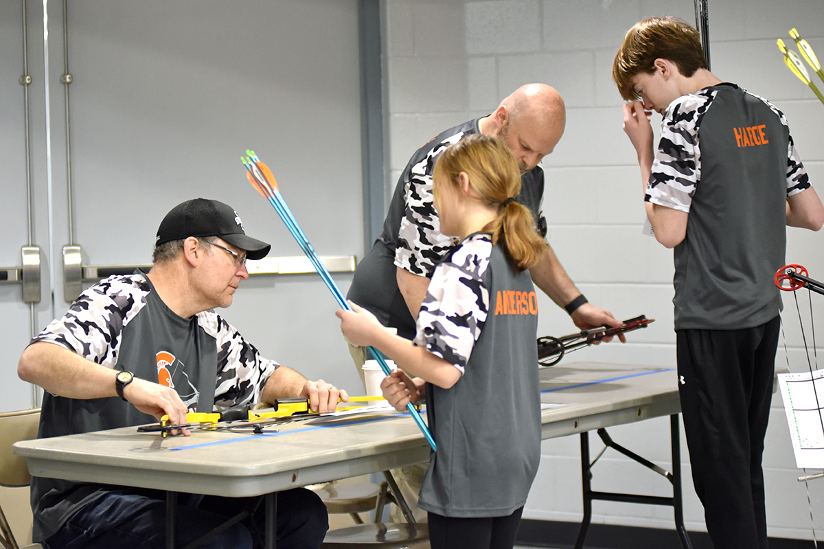 <p>Coaches Scott Smyth and Kent Ball inspect the bows of Hailey Anderson and MJ Haege before their flights during this past weekend’s tournaments.</p>