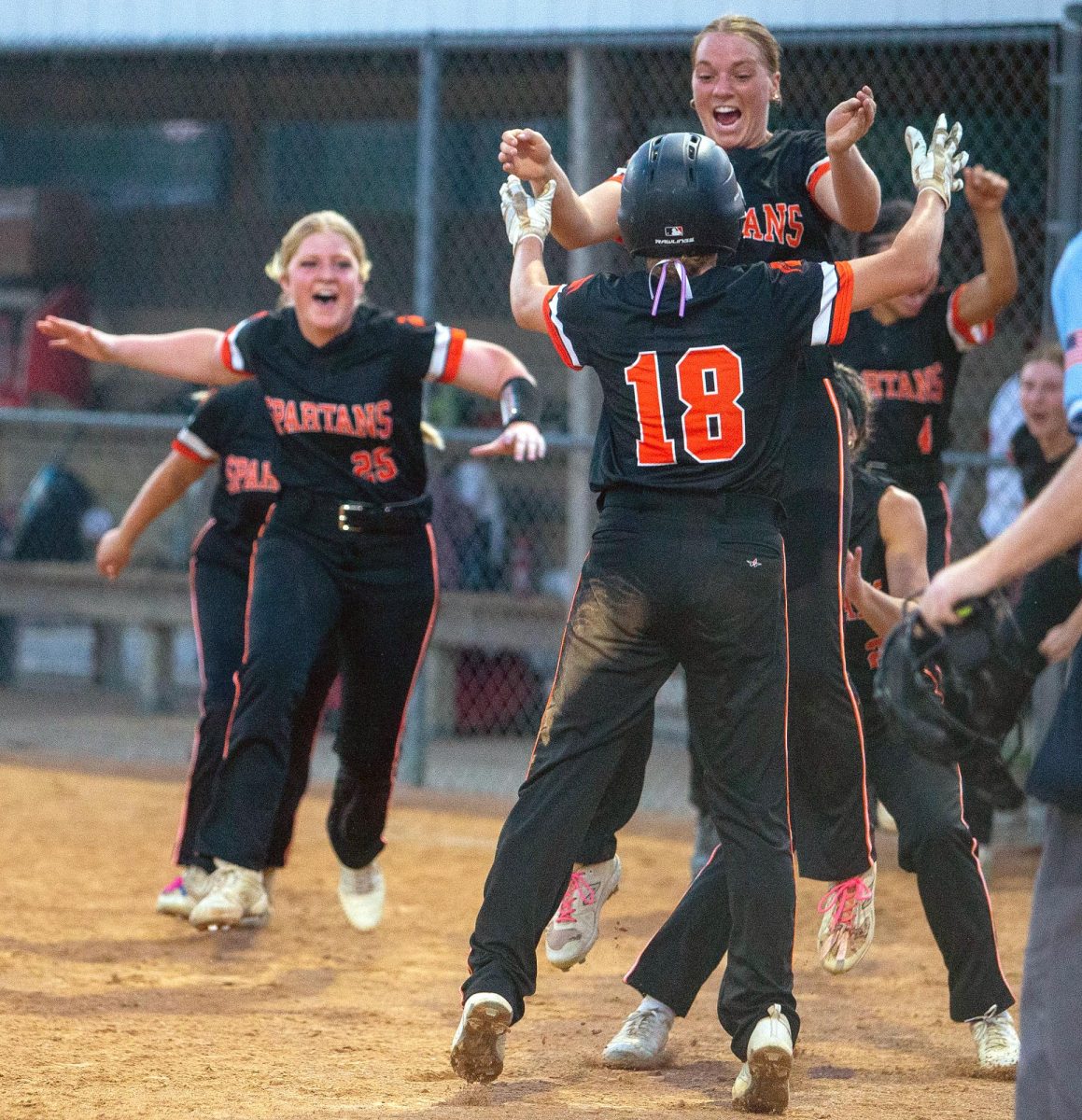 Keegan Kleppe (18) and Addie Miller (above) celebrate moments after Kleppe scored the game-winning run. The Lady Spartans mobbed Kleppe at home plate in celebration of securing their berth in the state tournament.