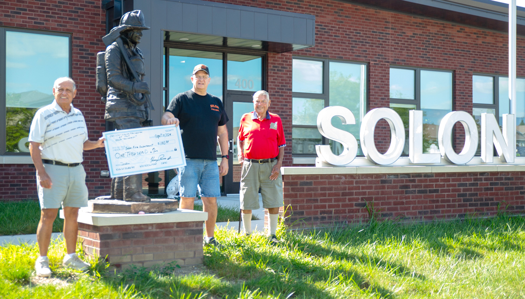 Fire Chief Bob Siddell receives a $1,000 donation from Henry Rios and Larry Swan, representing the American Legion of Iowa Foundation.
