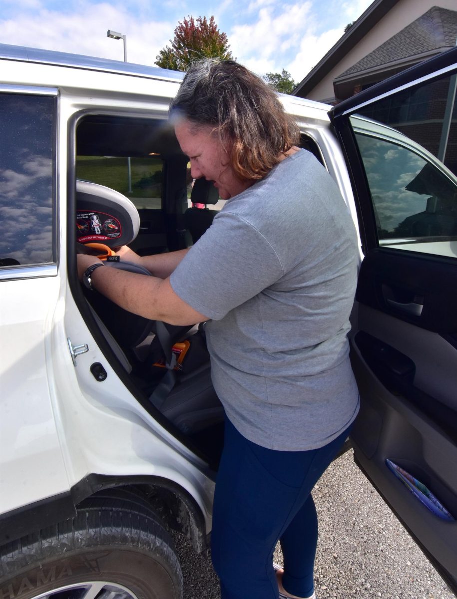 Alexis Kurth, Adult Services Librarian, installs a child safety seat in the backseat of a vehicle during a car seat safety inspection event Saturday, Sept. 21 at the Solon Public Library. Kurth and former Solon staffer Cassi Elton helped participants figure out the maze of straps, buckles, and clips to ensure proper use of the seats.