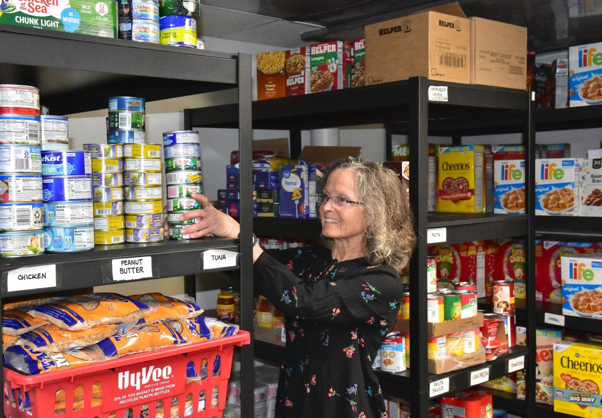 Elaine Claude, Director of the Solon Food Pantry, organizes a shelf in the Pantry, which continues to see an increase in requests for assistance.