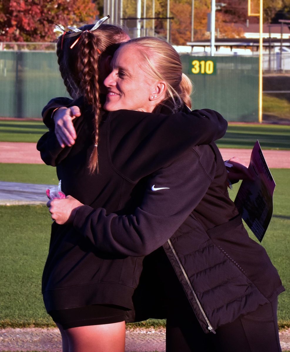 Solon cross country Coach Emy Williams embraces Sydney Dee during the award presentations at the 3A Regional Meet in October. Williams was named as one of five Class 3A At-Large Coach of Year recipients by the Iowa Association of Track Coaches.