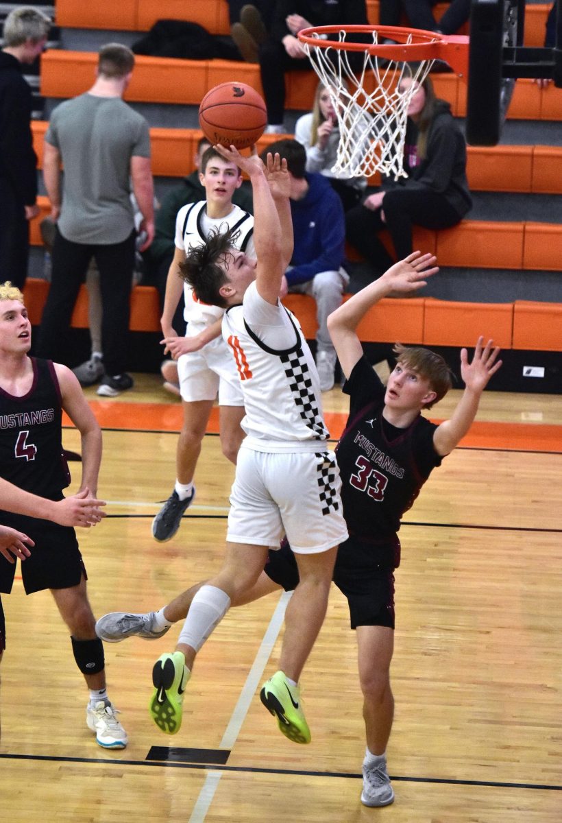 Sophomore Maddox Kelley (11) draws a foul from Mount Vernon sophomore Seth Rushford (33) in the second half of the varsity game Friday, Jan. 24 against Mount Vernon. The Spartans improved to 9-4 with a 58-41 upset of the Mustangs, who dipped to 11-3.