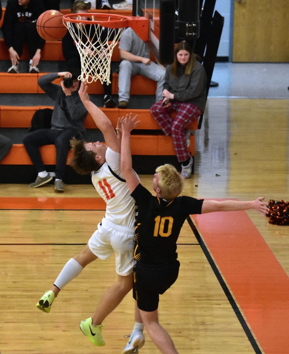 Maddox Kelley (11) puts up a two-point shot under pressure from CPU’s Lucas Lopata to beat the buzzer at the end of the third period Tuesday, Jan. 28, in Solon. The Spartans outlasted the Stormin’ Pointers 67-63 in double overtime with nine points from Kelley.