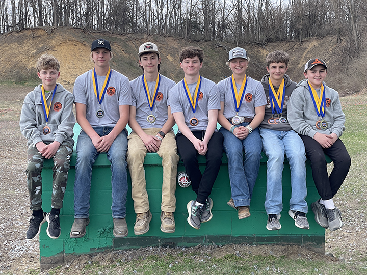 Solon trap shooters (From left) Charles Ferin, Caden Stull, Allen Shima, Kacey Craig, Alannah Mahoney, Connor Mahoney, and Arthur Martin sit on the trap house at the Muscatine Izaak Walton League displaying their medals won in their season opening meet against Wilton Saturday, March 29.