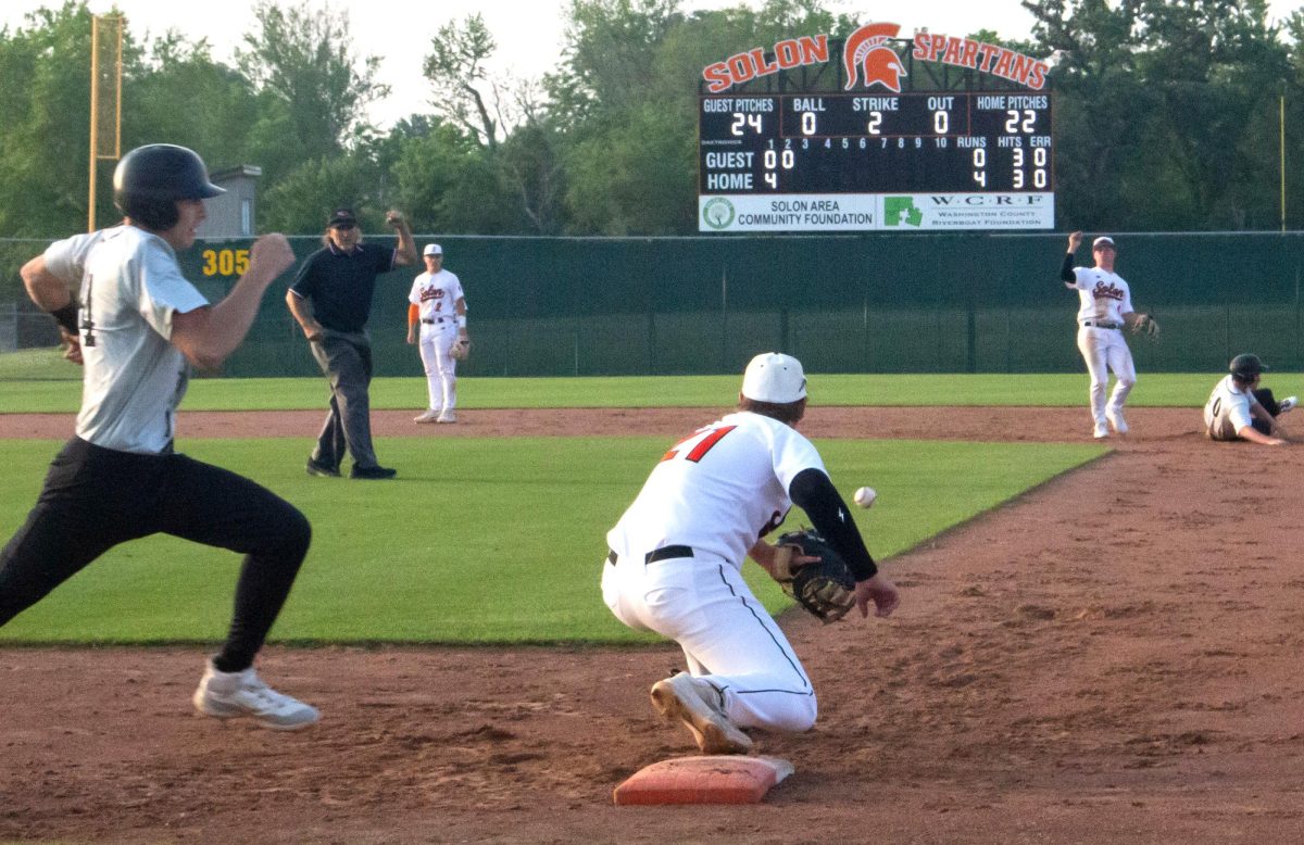 Jackson Link (21) receives the ball at first base ahead of a charging Viking Thursday, June 5. The Spartans swept Vinton-Shellsburg 4-3 and 12-0.