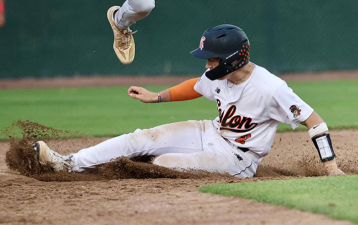 Maddox Kelley, a sophomore, slides in as a Cedar Rapids Washington Warrior leaps for the ball in varsity action
Thursday, June 12, in Solon. The Warriors edged the Spartans by one run to win 4-3.
