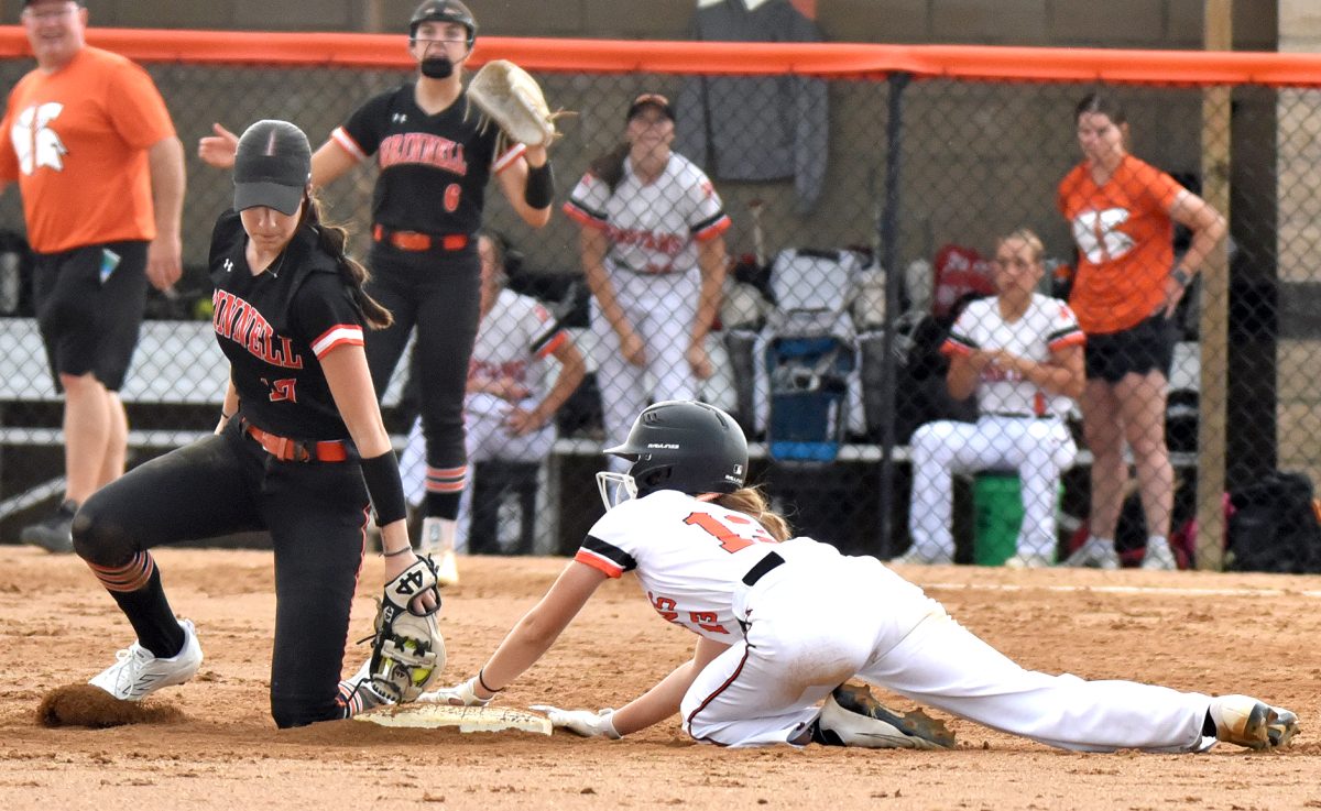 Dillion Ostrander, a junior, comes in safe to the delight of Coach Brad Holub and the disappointment of Grinnell’s Kylee Bond (17) and Kaitlyn Smith (6) Wednesday, June 18, in Grinnell.