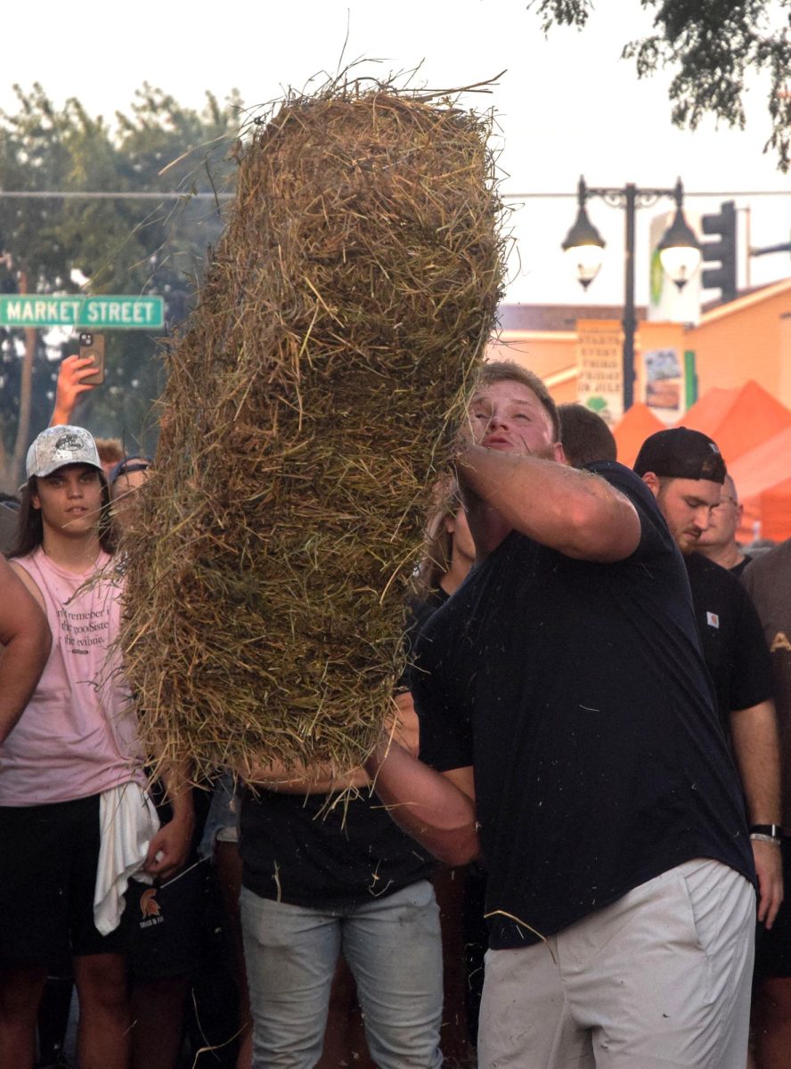 Iowa football lineman Kade Pieper muscles a hay bale at the annual Hay Bale Toss during Solon Beef Days Friday, July 18. Pieper defended his 2024 win with a 13’ toss in a showdown to claim the 2025 Championship.