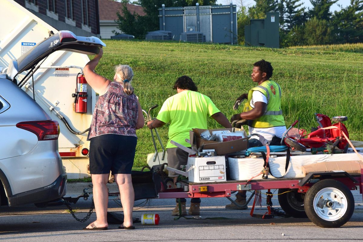 A resident unloads items from a trailer as workers from LRS-Johnson County Refuse assist during Solon’s annual Clean Up Day community garbage drop-off Saturday, August 9, at the Solon Recreation and Nature Area.