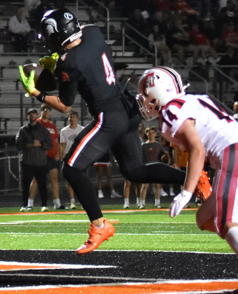 Maddox Kelley, a junior, takes a pass from senior quarterback Eli Kampman as the Spartans take on the Knights of Davenport Assumption Catholic Friday night in Solon. The Spartans scrapped the Knights 36-13.