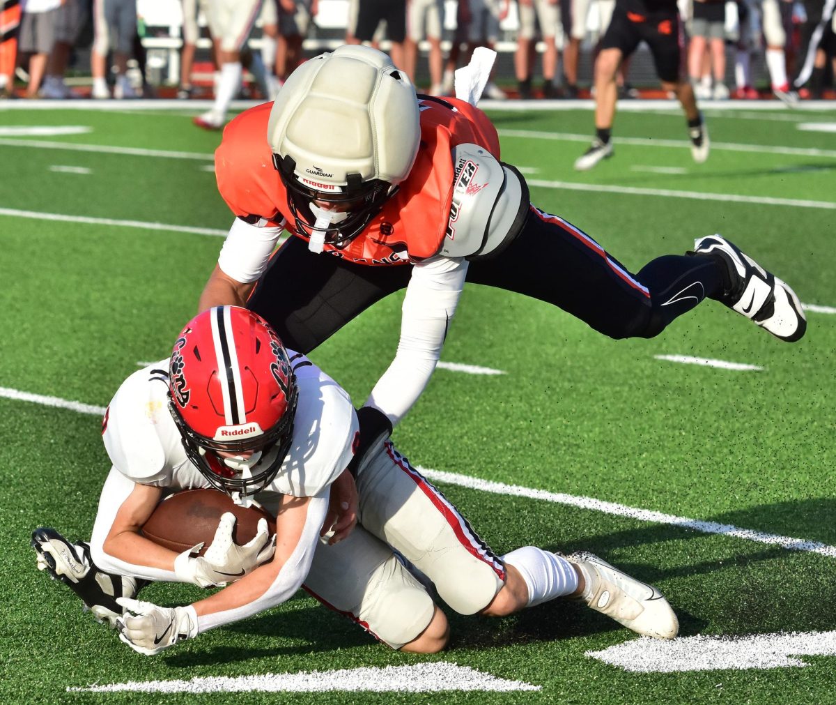 Eli Kampman (3) tackles a Linn-Mar Lion Friday, August 22, at home in a varsity scrimmage. The regular season starts this Friday as Assumption Catholic (Davenport) visits for a non-district